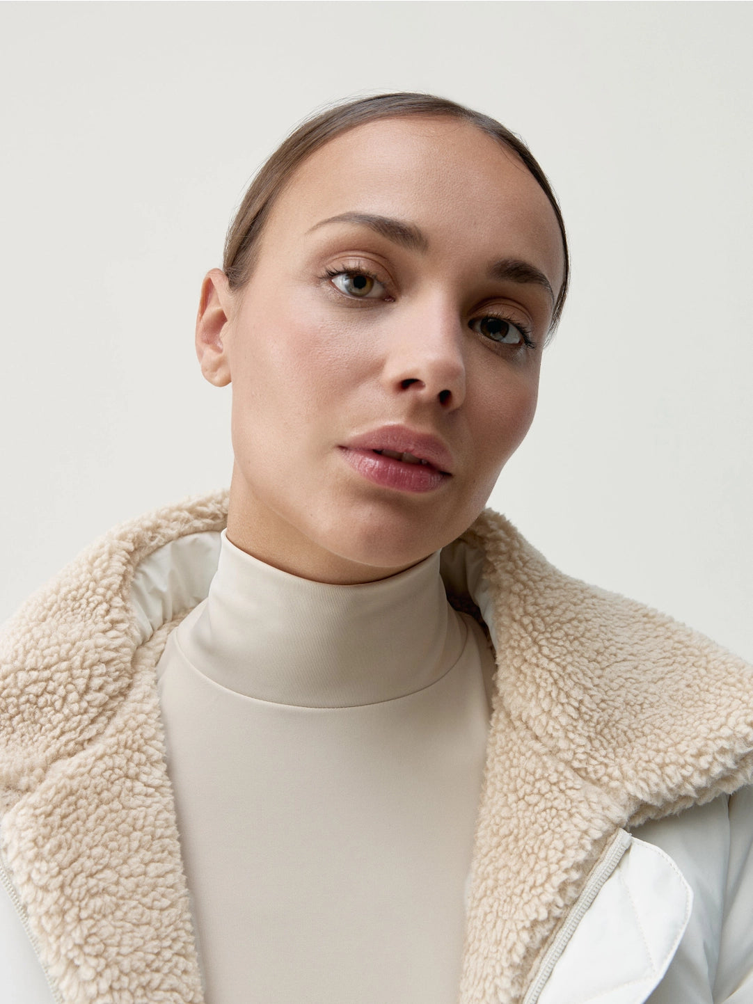 Närbild på modell med vit jacka