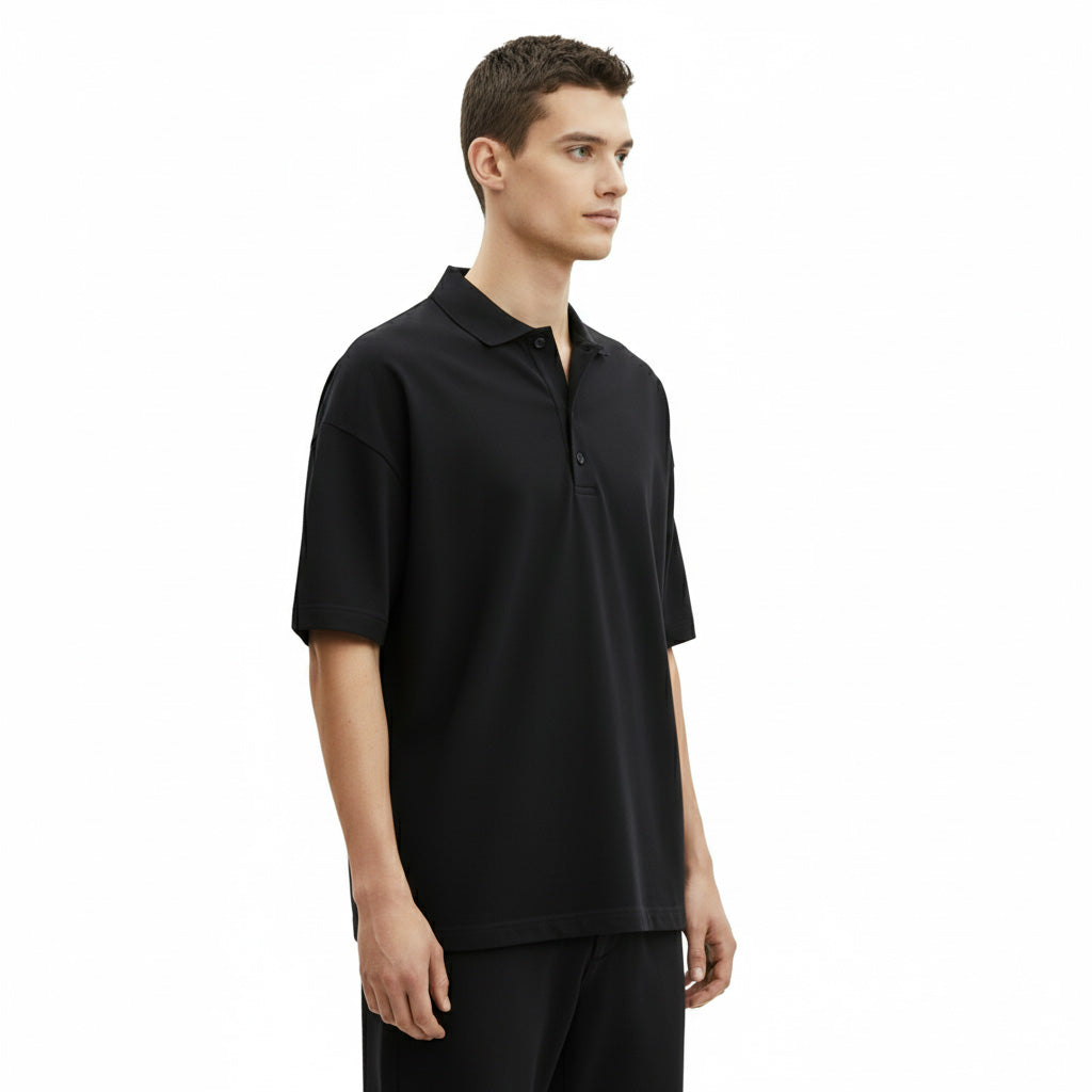 Manlig modell från sidan som bär svart loose fit piké från wearly.se profilkläder
